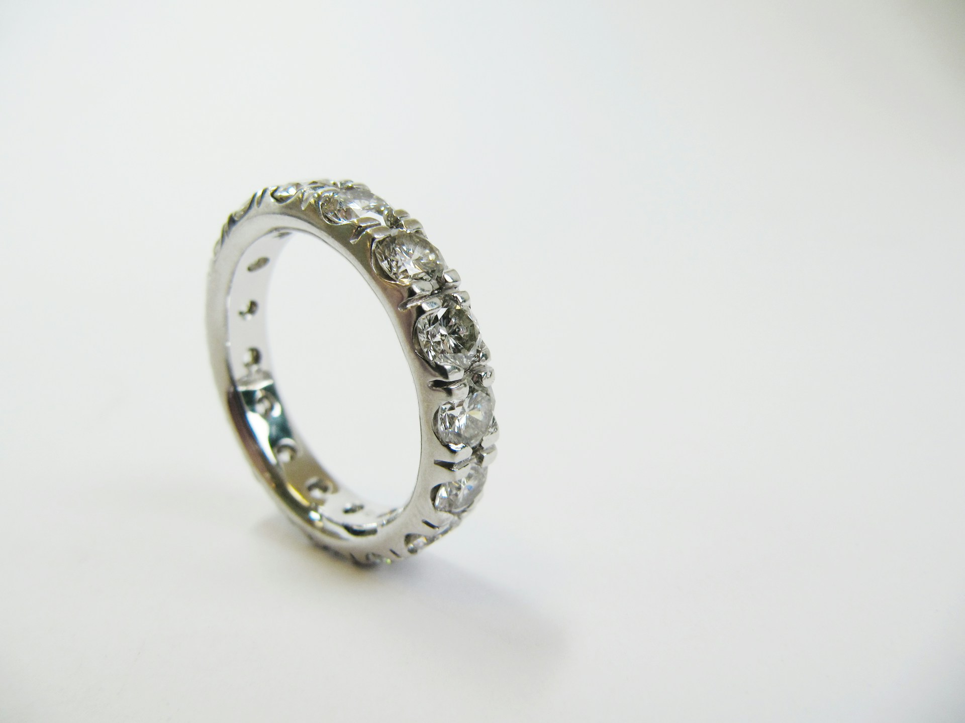 a platinum and diamond wedding band on a gray background