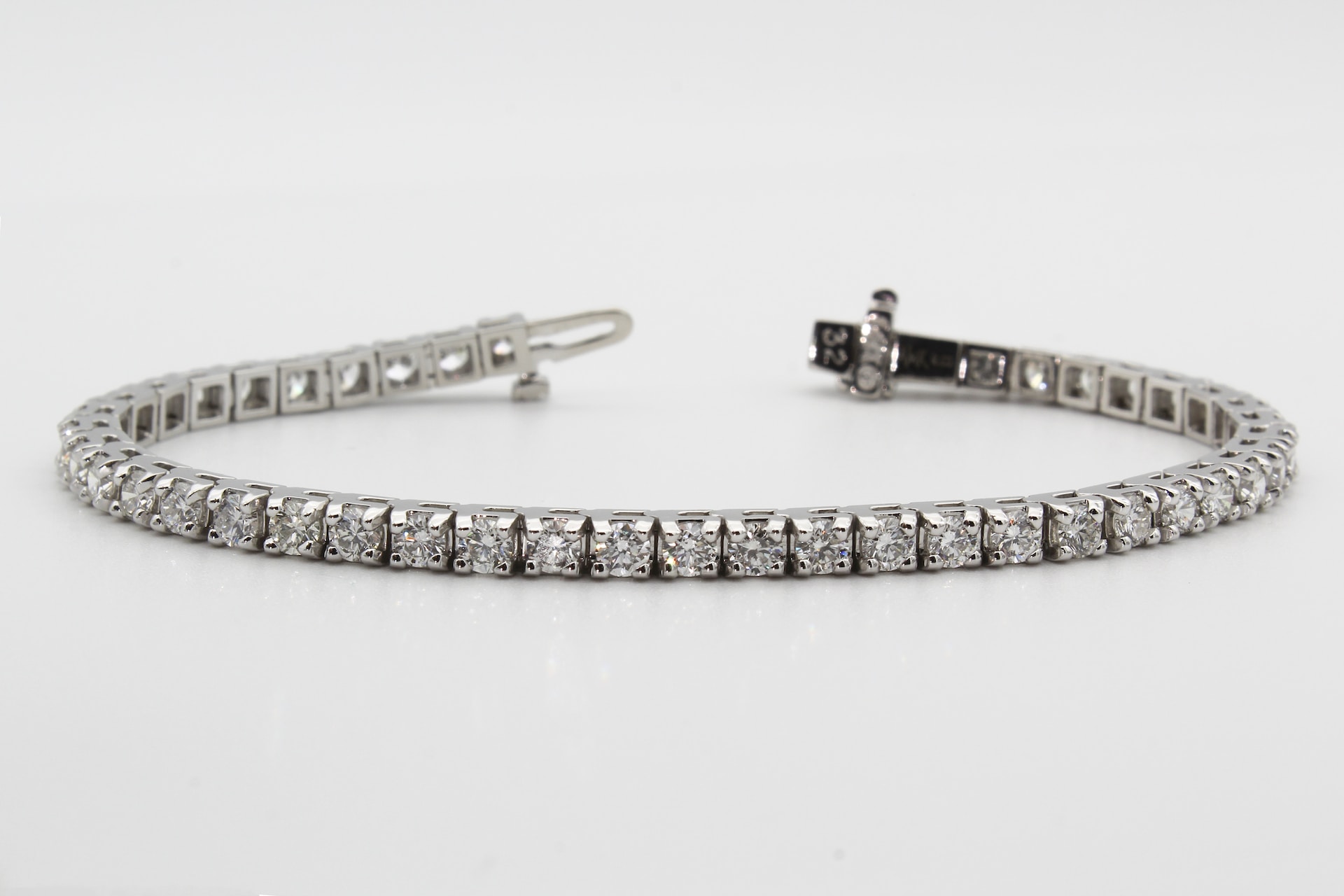 platinum and diamond bracelet on a gray background