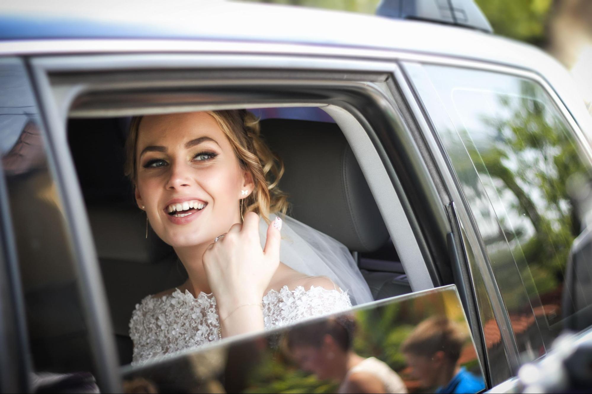 a bride says goodbye to her wedding guests as she leaves the reception.