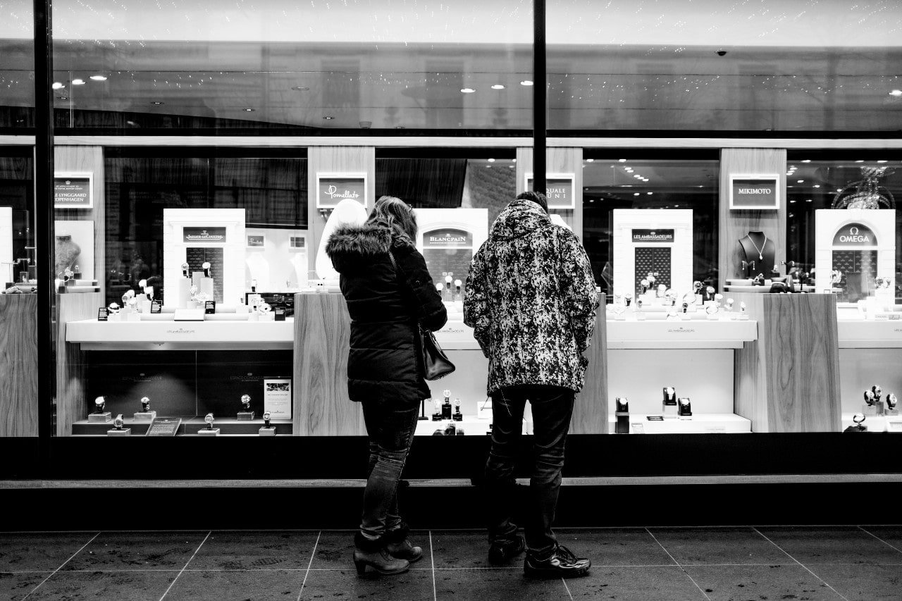 A young couple window shopping at a local jewelry store.