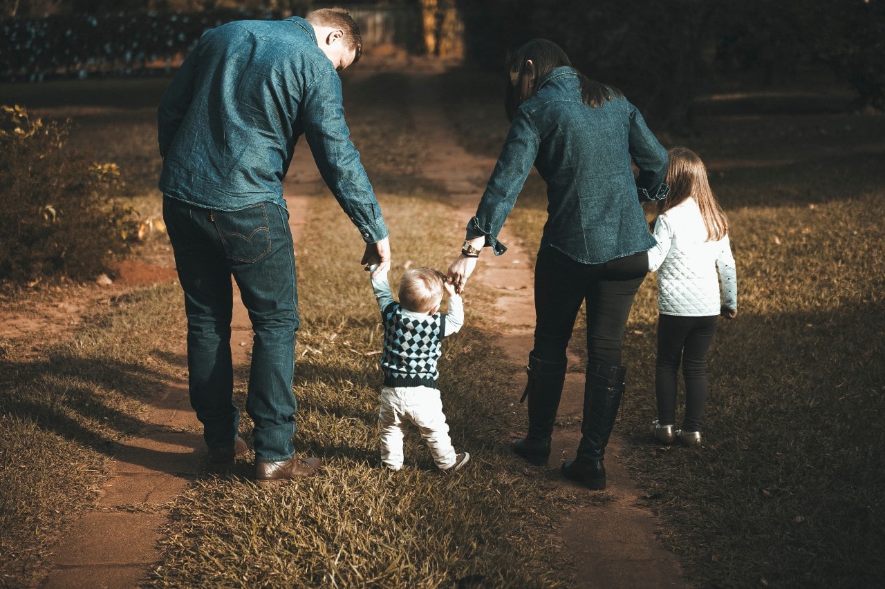 A young family walking along a path in the winter.