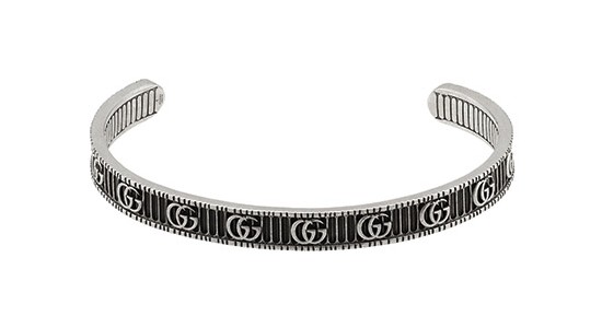 a sterling silver cuff bracelet by Gucci with black details and the Gucci logo