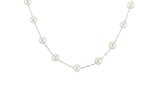 A silver station necklace dotted with freshwater pearls