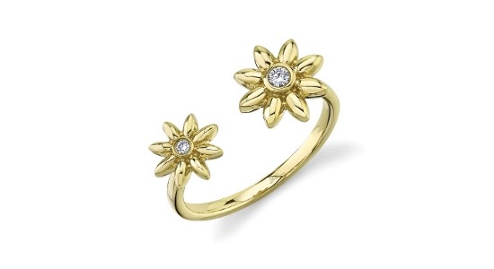 A thin, yellow gold ring that features a break and two flower motifs with diamond accents
