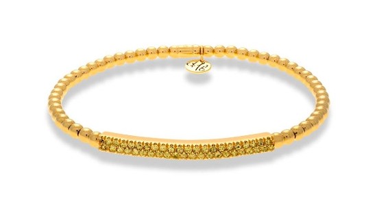 Close up image of a gold bangle with beading details and yellow diamonds