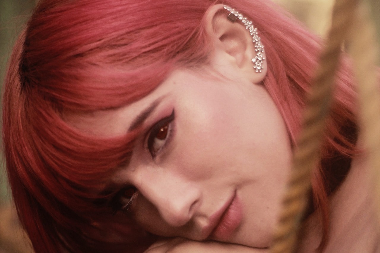 A woman with pink hair wearing a diamond ear climber