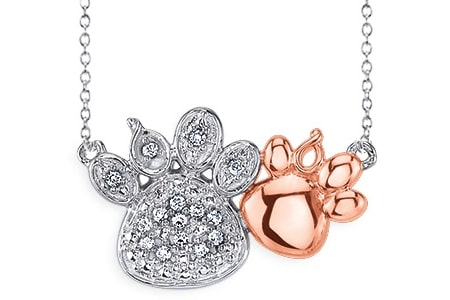 A sterling silver paw print pendant features diamonds and pink micron plating
