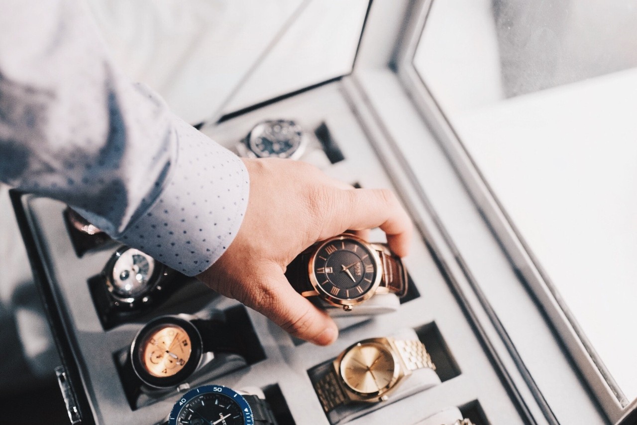 A man selects a watch from his collection in a tray insert in one of his drawers