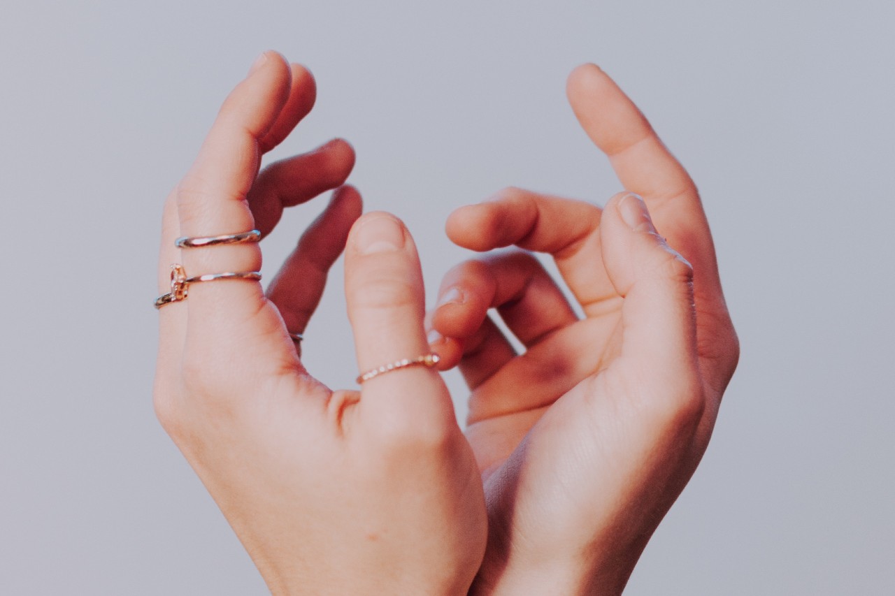 A woman sporting multiple rings shows off her layered ring technique