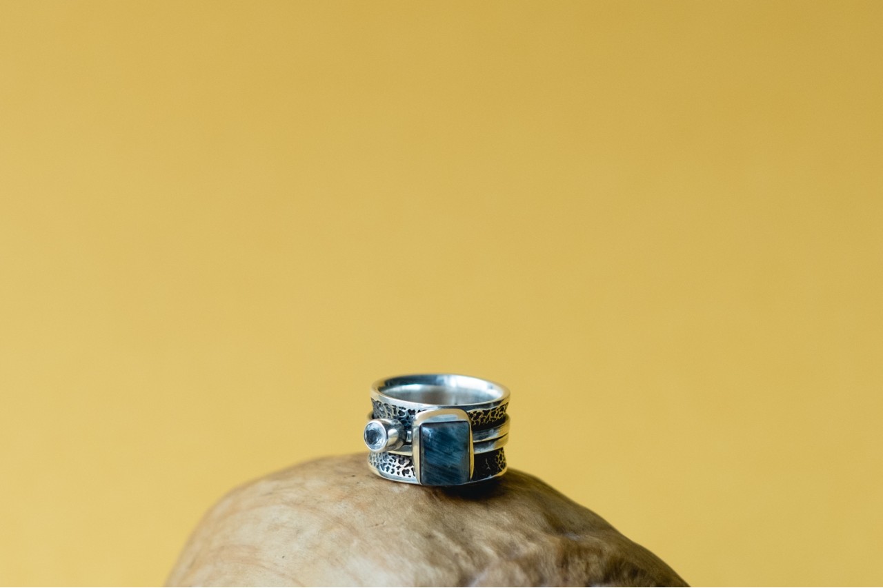 Sterling silver fashion ring with labradorite gemstone sitting on a rock