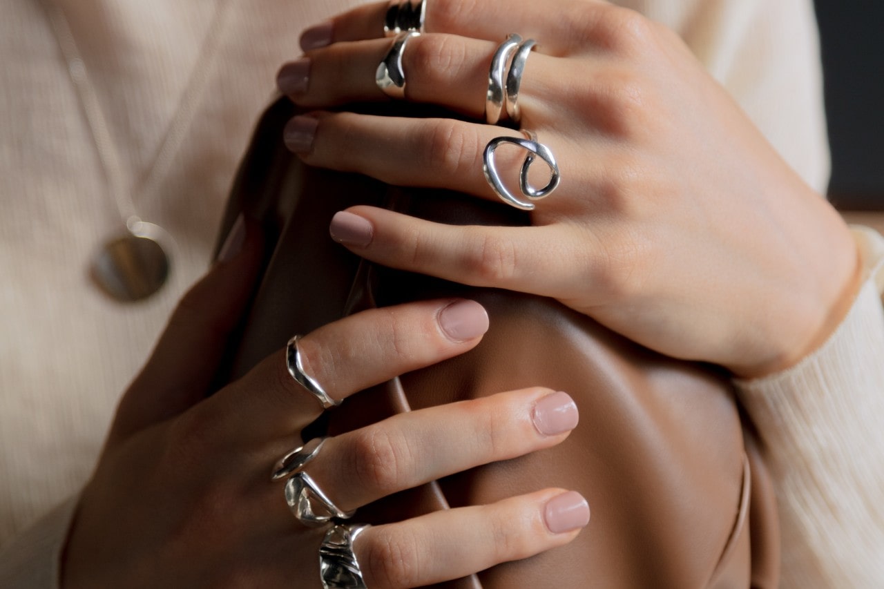 A woman’s hands wearing a number of white gold fashion rings