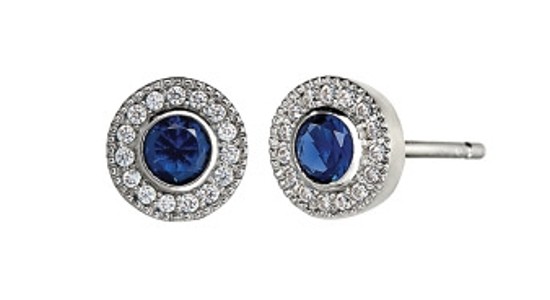 a silver pair of stud earrings featuring bezel set sapphires and diamond halos