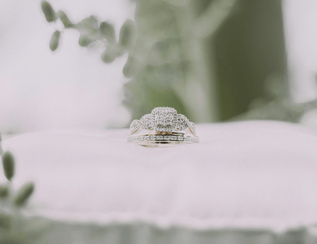 wedding ring and band sitting on a pillow