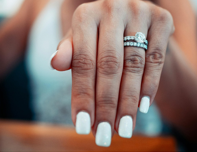 woman's hand wedding a wedding ring and band on her ring finger