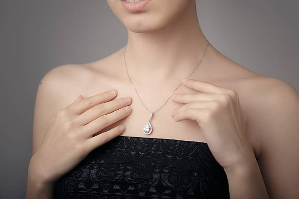 Woman wearing a diamond necklace and a black dress.