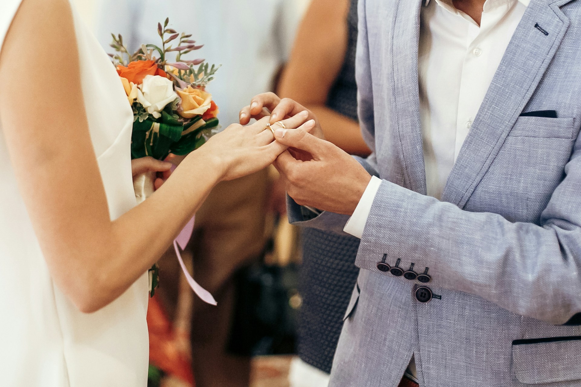 a groom putting a wedding ring on his bride’s finger