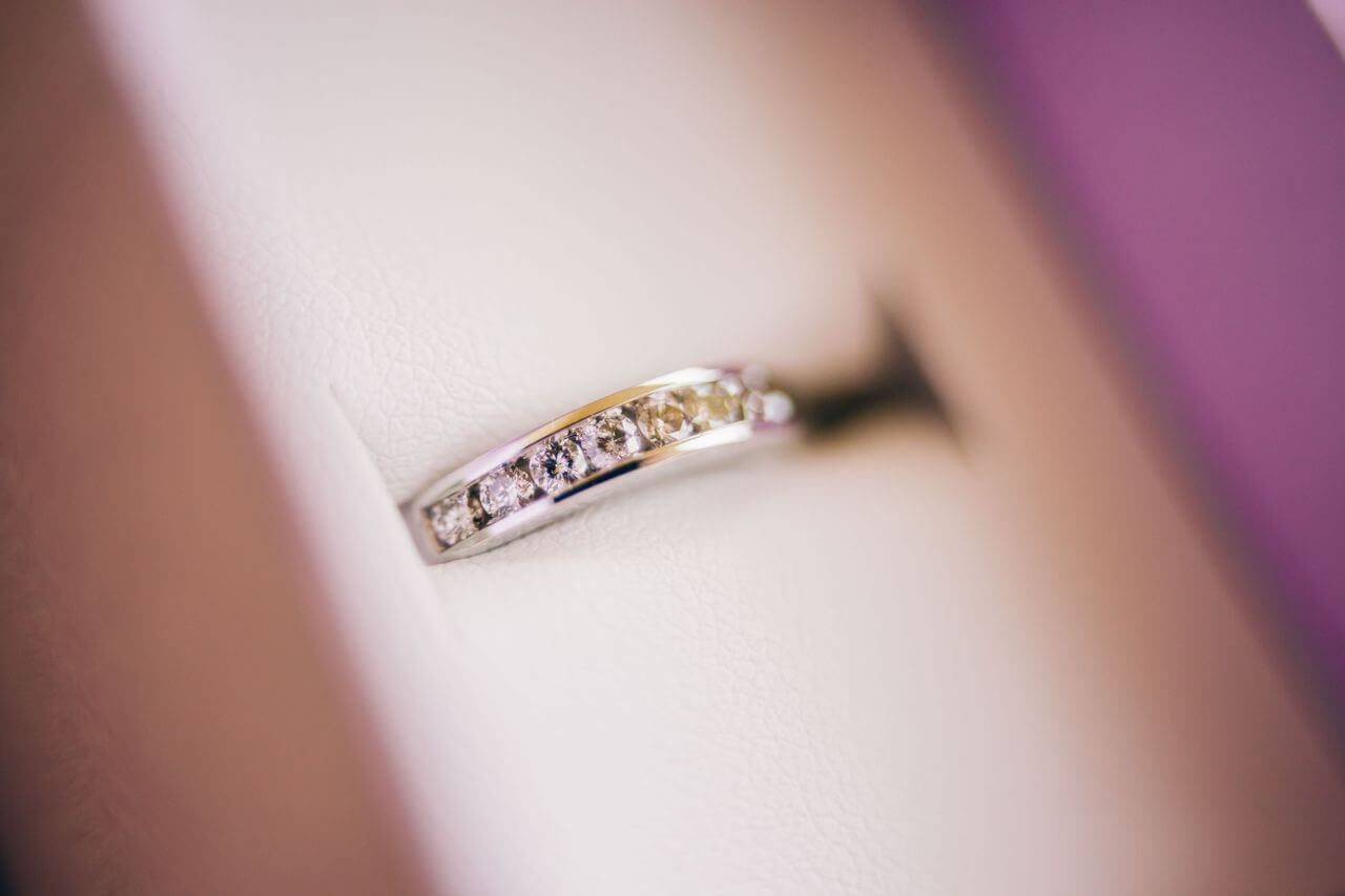 A close-up of a yellow gold wedding ring with channel set diamonds.